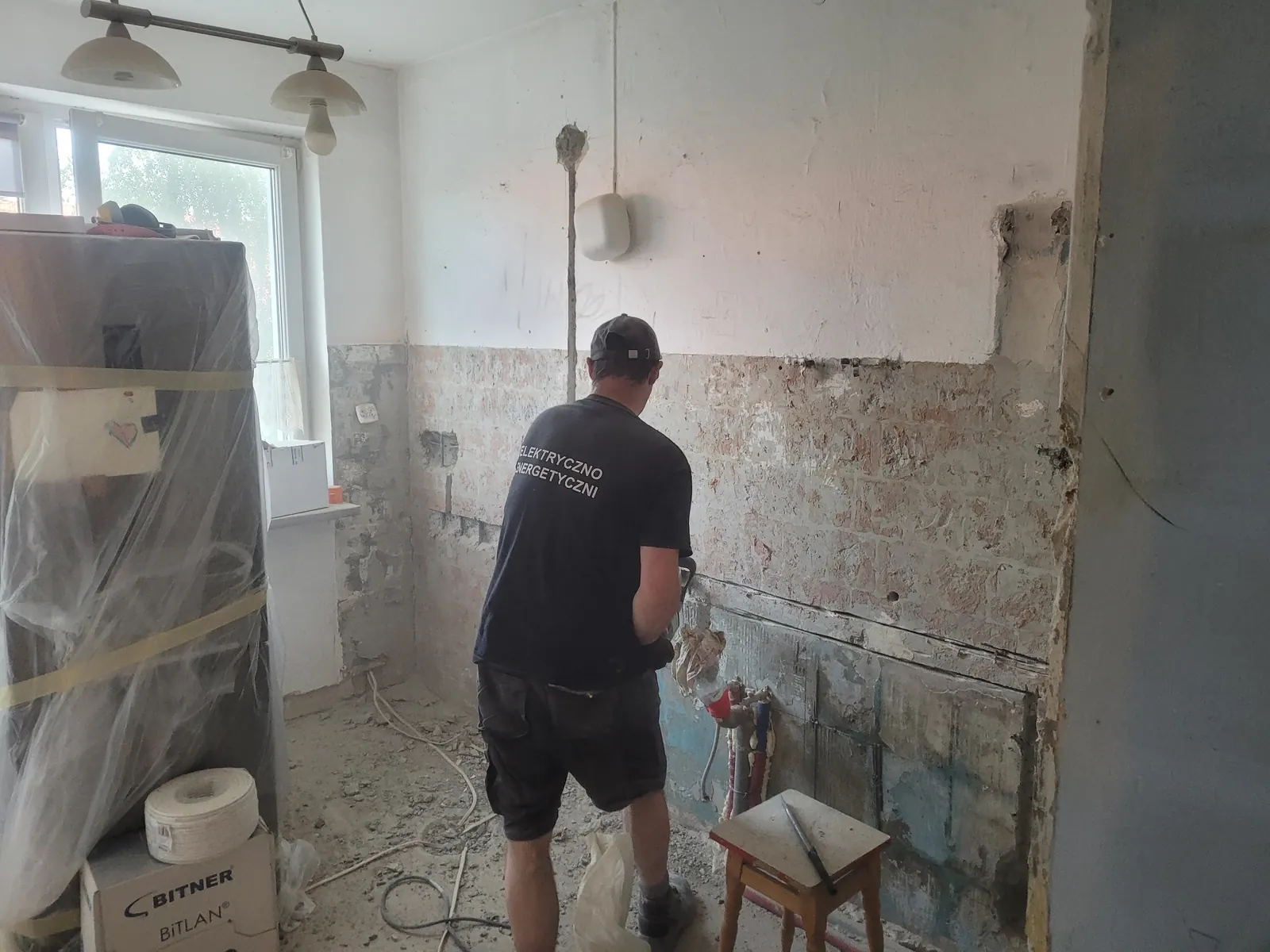Elektryk przy pracy podczas wymiany instalacji w mieszkaniu